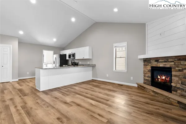 a view of kitchen with granite countertop fireplace and wooden floor