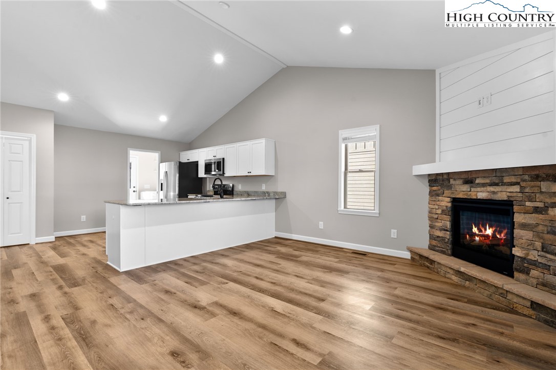 233 Ava Way, Unit 109 Boone, NC 28607 - Photo 8 of 26 a view of kitchen with granite countertop fireplace and wooden floor