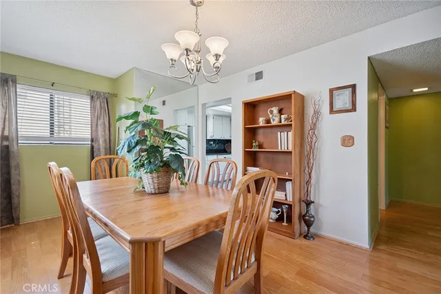 a view of a dining room with furniture wooden floor and chandelier
