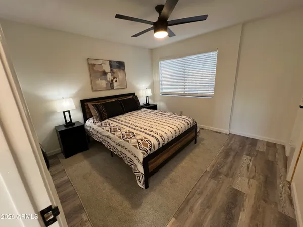 a bedroom with a bed painting on wall and wooden floor