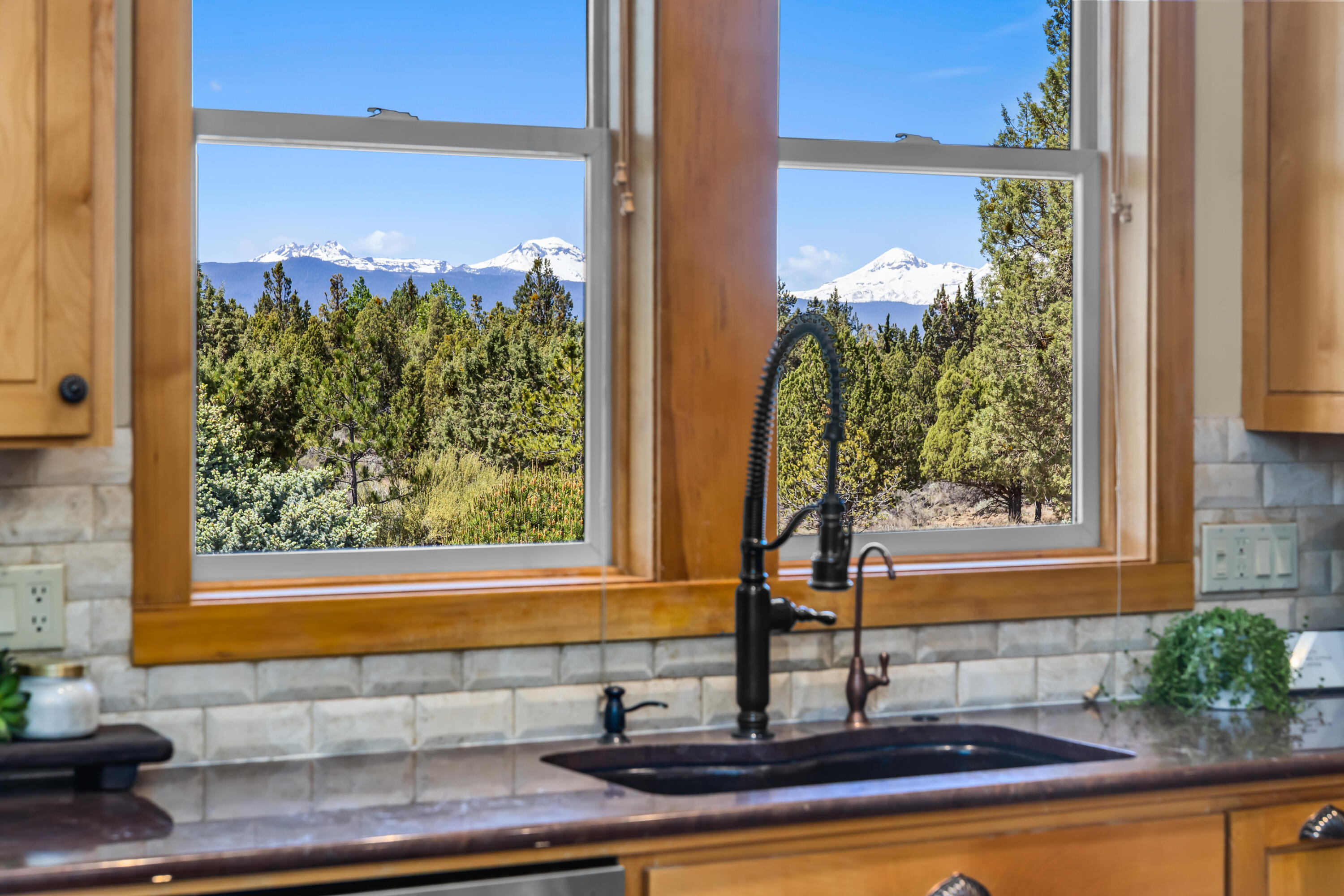 64145 Hunnell Road Bend, OR 97703 - Photo 16 of 65 Cascade Mountain views are thoughtfully framed throughout the home, including from the kitchen sink, where the peaks become part of the everyday living experience.