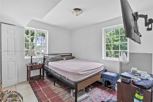 a bed sitting in a bedroom next to a window