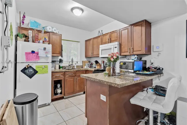a kitchen with stainless steel appliances granite countertop a sink dishwasher stove refrigerator and cabinets