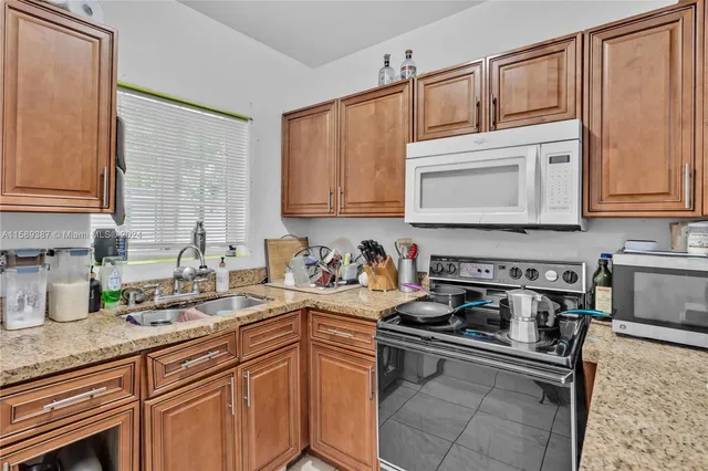 a kitchen with stainless steel appliances granite countertop a sink stove and cabinets