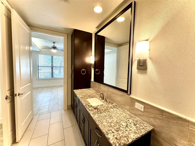 a bathroom with a granite countertop sink and shower