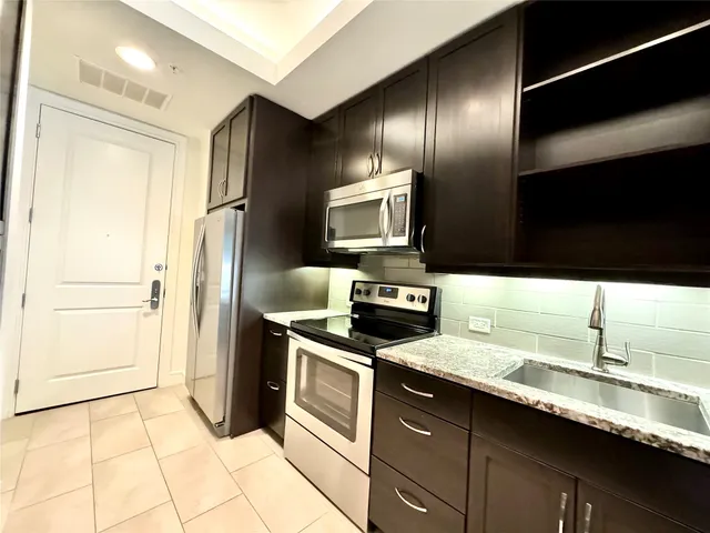 a kitchen with stainless steel appliances a sink stove and refrigerator