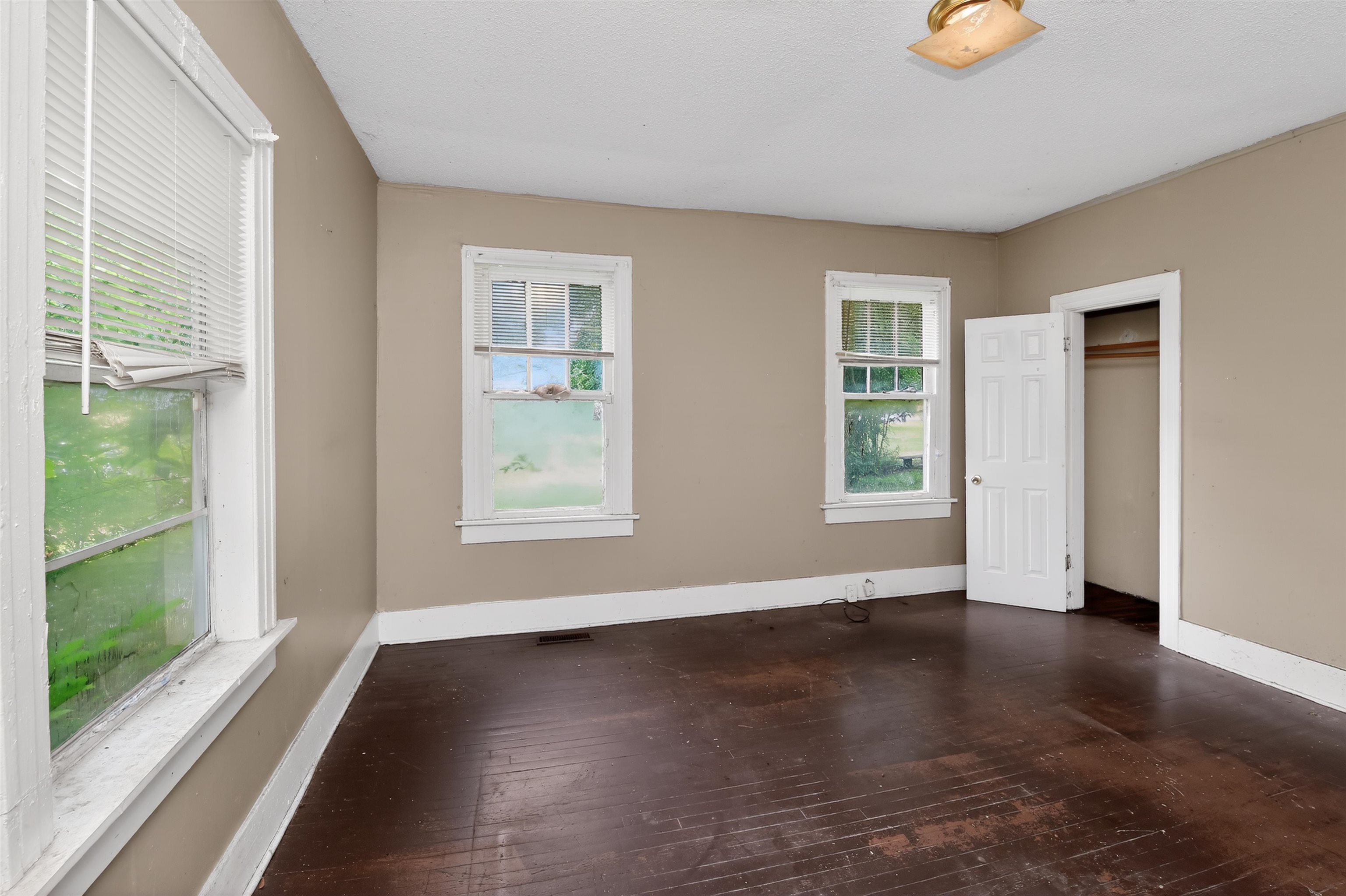 810 Hale Road Memphis, TN 38116 - Photo 19 of 30 Spacious room featuring dark wood-finish flooring, light tan wall color, and white trim