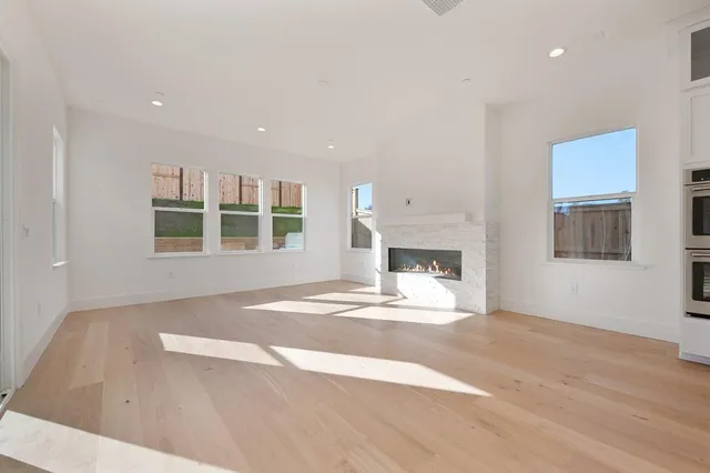 a view of an empty room with a window and fireplace