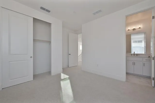 a view of an empty room with window and bathroom