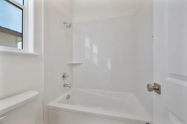 a white bath tub sitting next to a white toilet