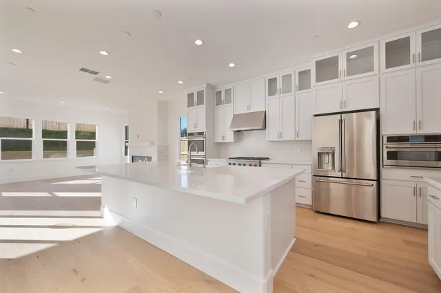 a kitchen with stainless steel appliances granite countertop a refrigerator and a sink