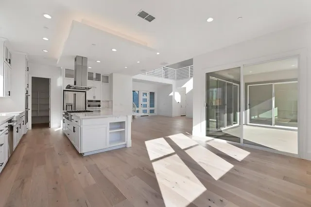 a open kitchen with kitchen island a sink and a stove top oven