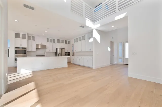 a view of a kitchen with refrigerator and a living room