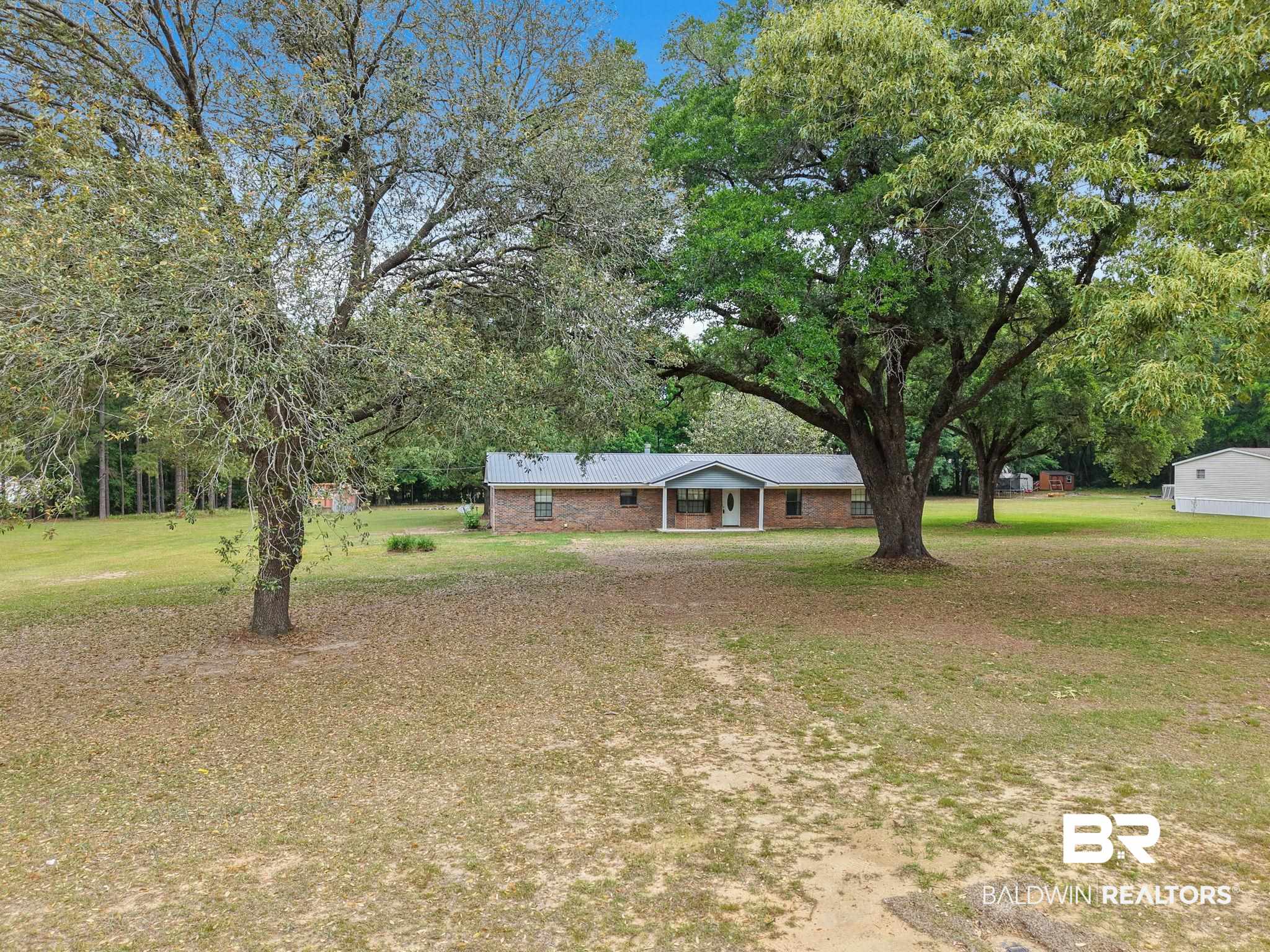 13653 Roberts Road Loxley, AL 36551 - Photo 1 of 33 Brick exterior residence with a covered front porch and a light-colored entry door