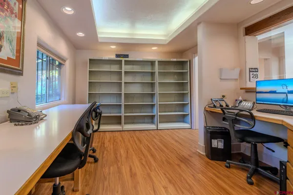 a view of a workspace with furniture and wooden floor