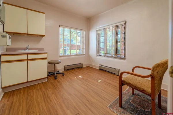 a view of a workspace with furniture and a window