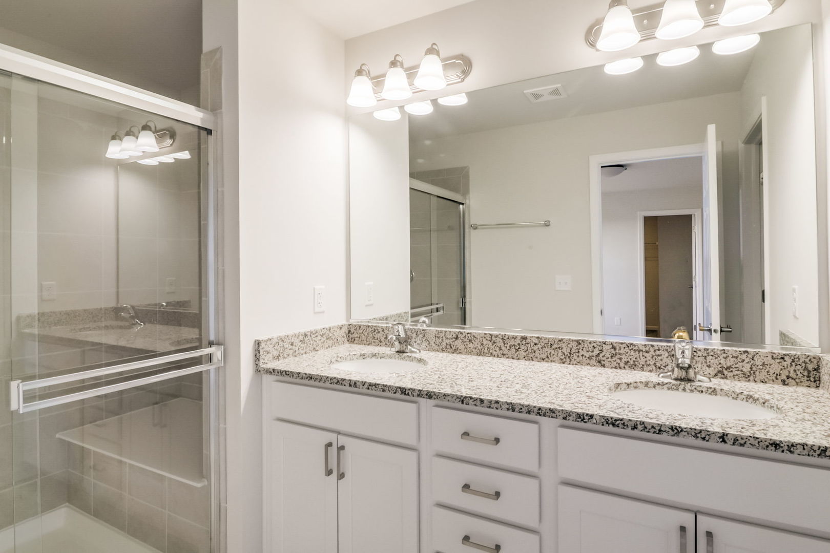 715 Maplewood Circle Elburn, IL 60119 - Photo 19 of 32 a bathroom with a granite countertop sink a large mirror and a shower
