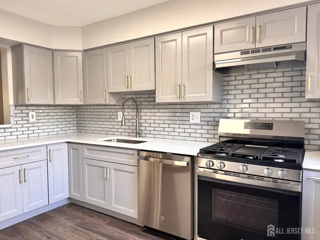 a kitchen with granite countertop a stove sink and cabinets