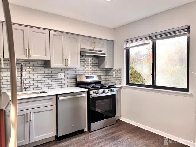 a kitchen with stainless steel appliances white cabinets and a stove