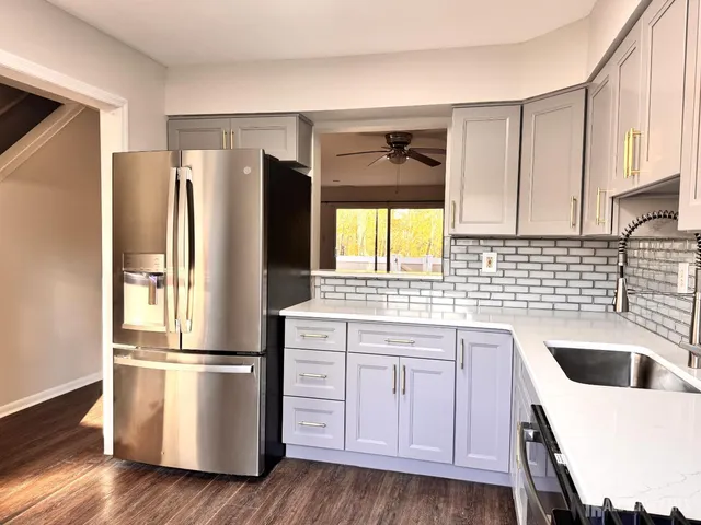 a kitchen with a refrigerator sink and cabinets