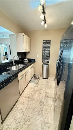a kitchen with stainless steel appliances kitchen island granite countertop a stove a sink and a refrigerator