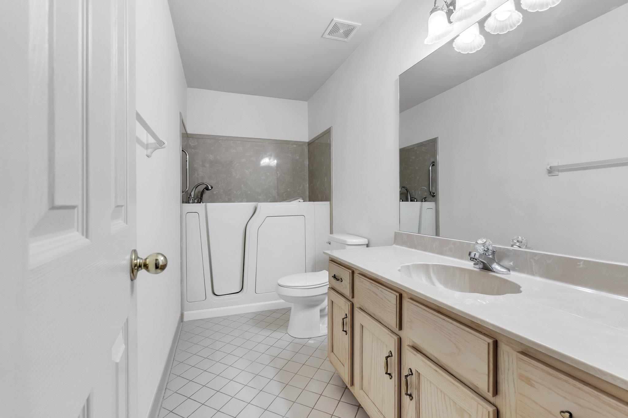 6307 Thistle Point Bartlett, TN 38135 - Photo 12 of 31 a bathroom with a double vanity sink a toilet and a mirror