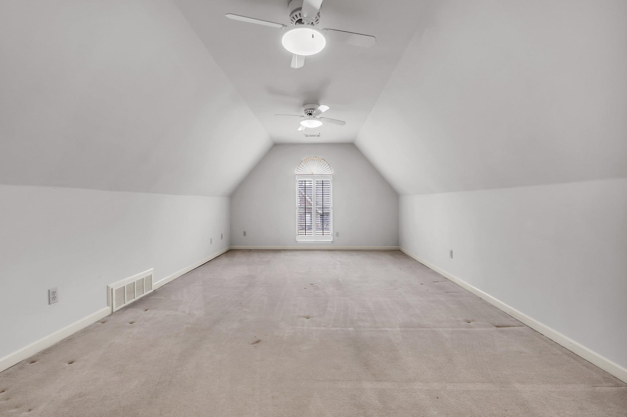 6307 Thistle Point Bartlett, TN 38135 - Photo 14 of 31 an empty room with a chandelier fan and windows