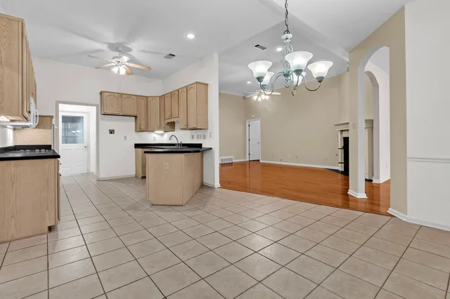 a spacious bathroom with a granite countertop sink a mirror and a shower