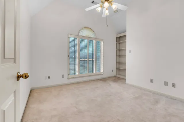 an empty room with chandelier fan