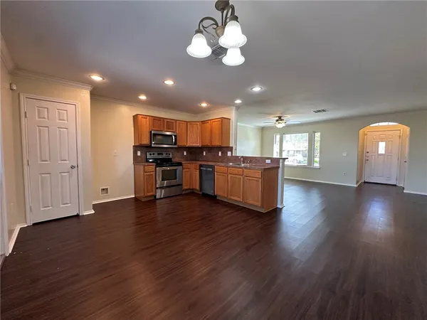 a view of a kitchen with furniture wooden floor and stainless steel appliances