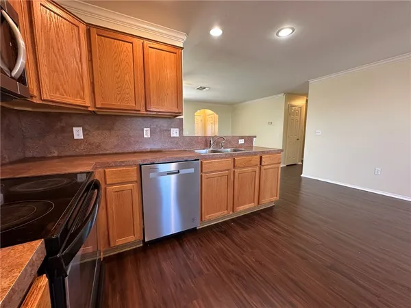 a kitchen with wooden floors and wooden cabinets