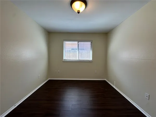 a view of a room with wooden floor and a window