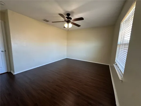 a view of wooden floor and a chandelier fan in a room