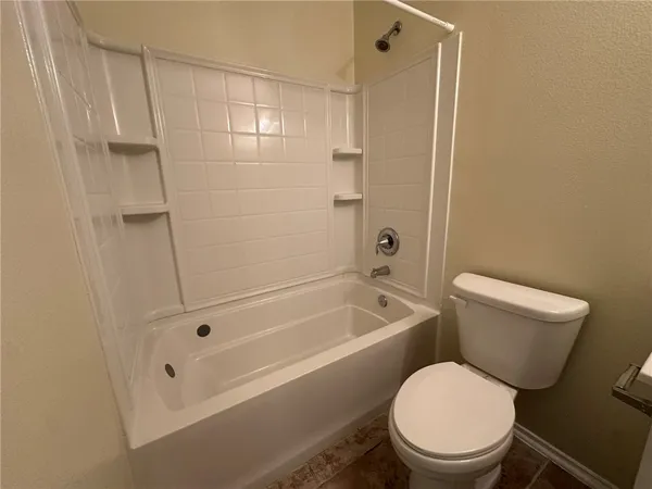 a white toilet sitting next to a bath tub