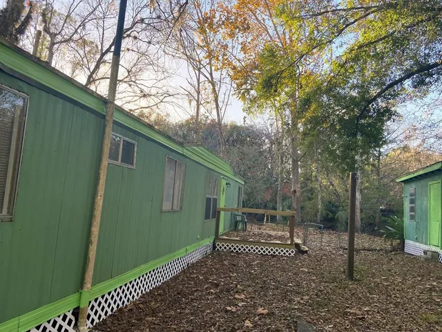 a green field with some trees in front of it