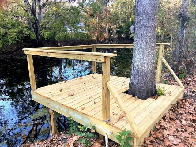 a view of a patio with table and chairs with wooden floor and fence