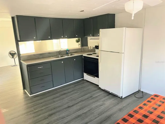 a kitchen with granite countertop a refrigerator and a sink