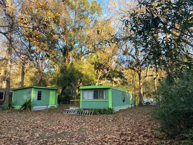 a house is sitting in middle of forest