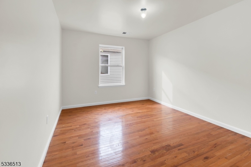 58 1st Street, Unit 3 Newark, NJ 07107 - Photo 14 of 19 an empty room with wooden floor and windows