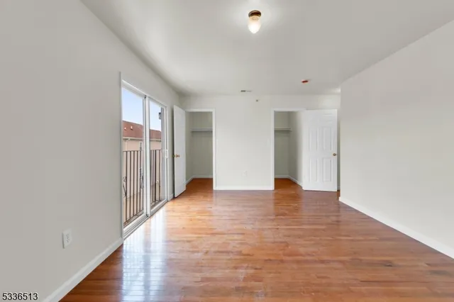 a view of an empty room with wooden floor