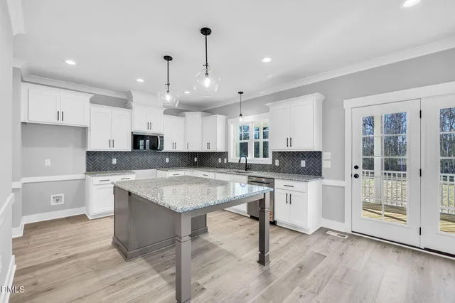 a kitchen with center island wooden floor center island and stainless steel appliances
