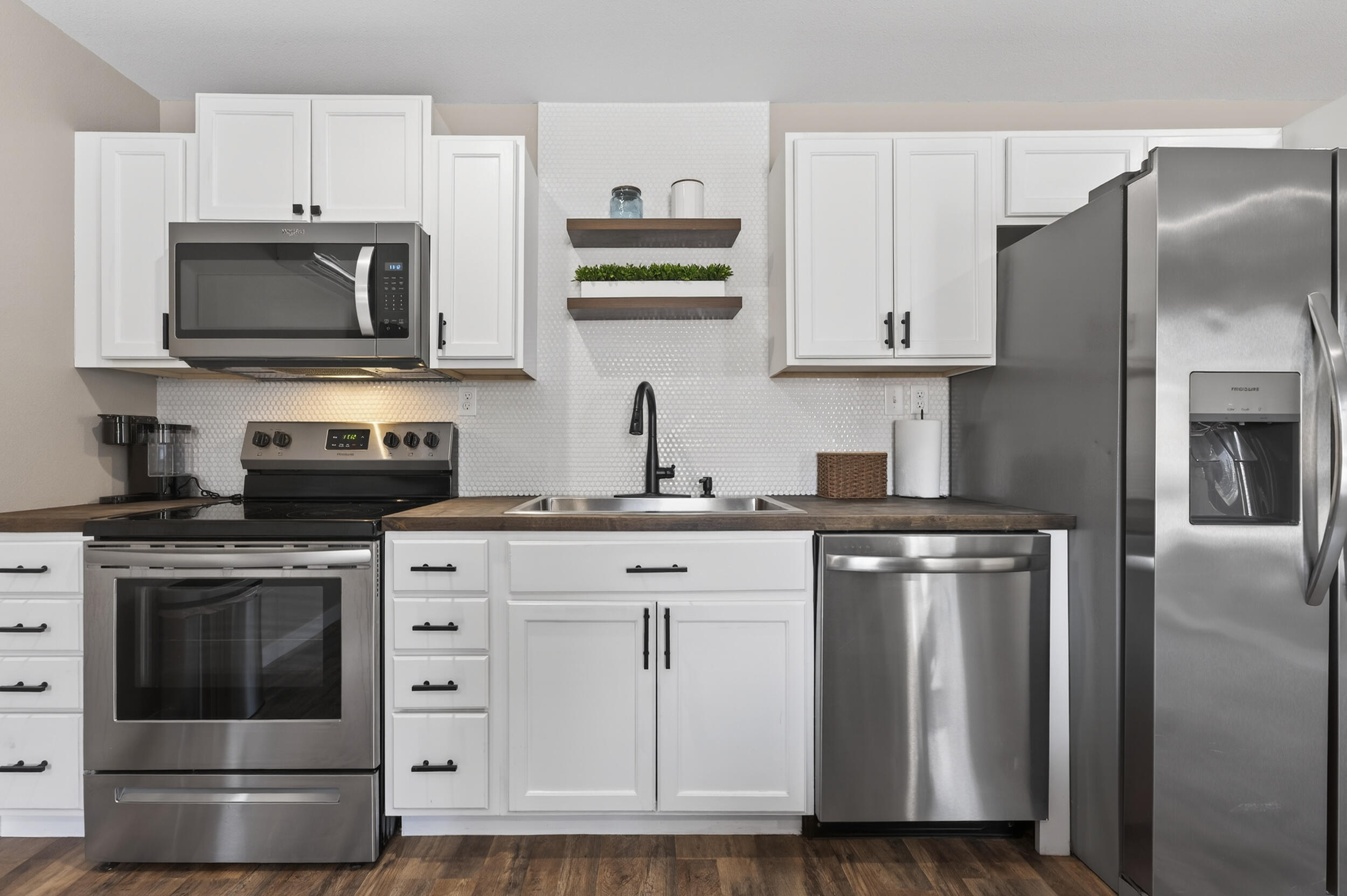 60 McDaniels Fishcamp Road, Unit A Freeport, FL 32439 - Photo 7 of 67 a kitchen with white cabinets and stainless steel appliances