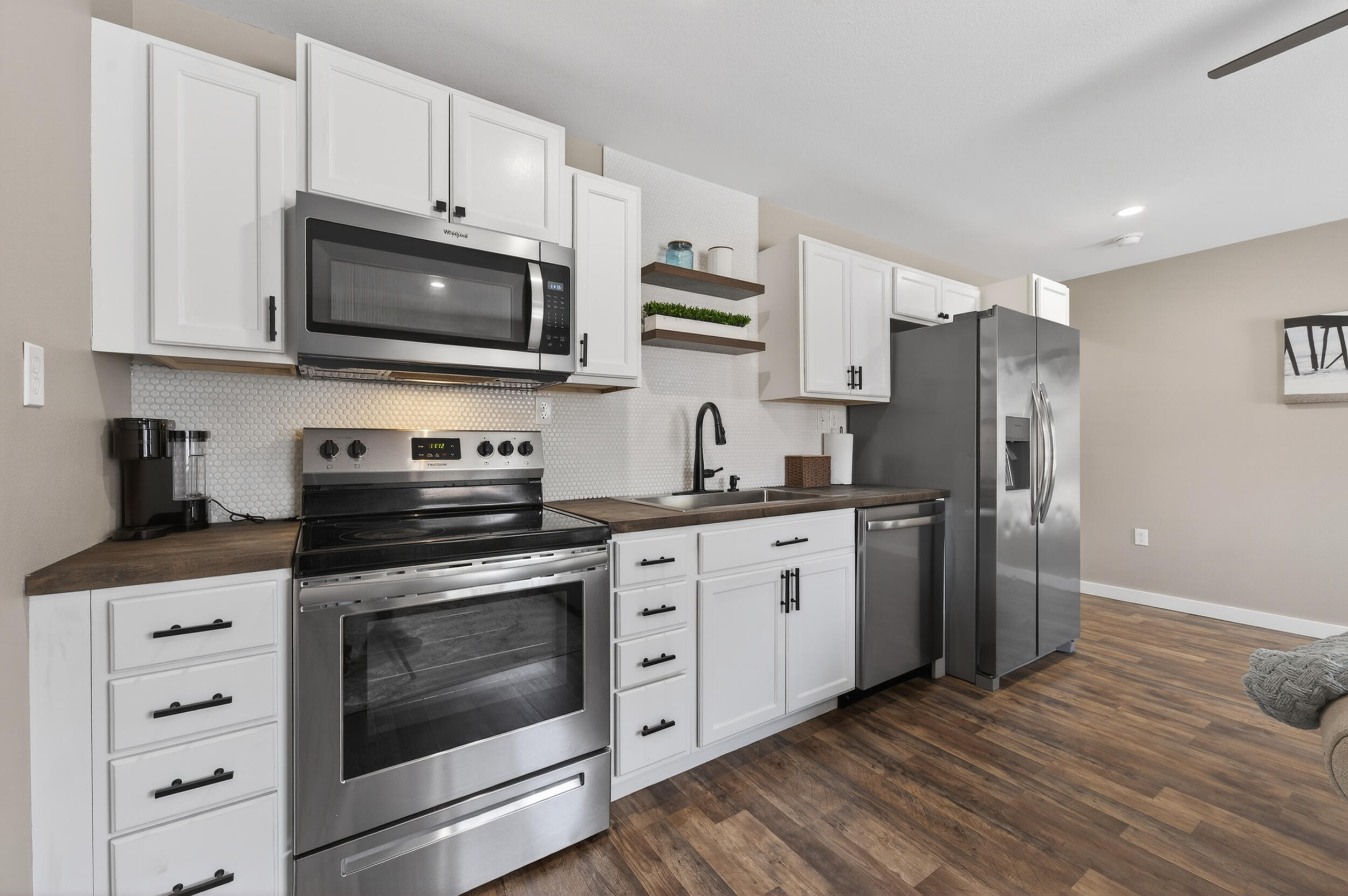 60 McDaniels Fishcamp Road, Unit A Freeport, FL 32439 - Photo 8 of 67 a kitchen with stainless steel appliances white cabinets a stove a microwave and a refrigerator