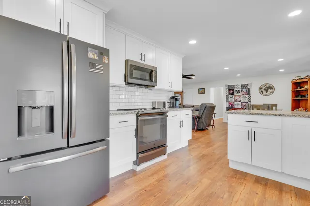 a kitchen with white cabinets and window