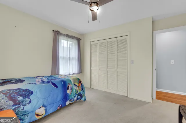 a bedroom with a bed and a painting on the wall