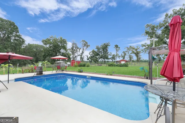a view of a house with a yard and large trees