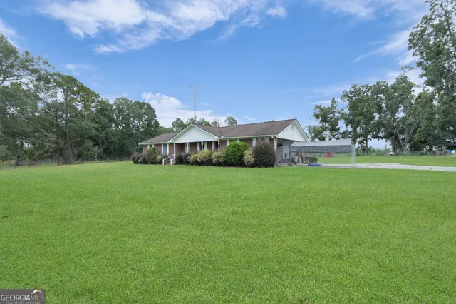 a front view of a house with garden and trees