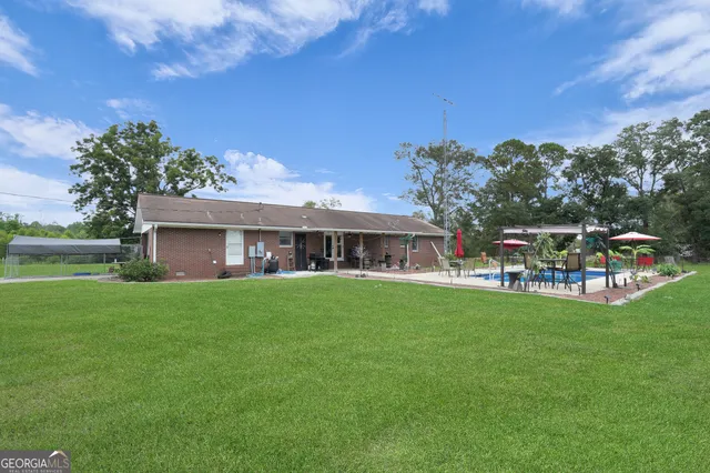 a view of a lake with a yard and large trees