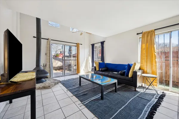 a living room with furniture a flat screen tv and a floor to ceiling window