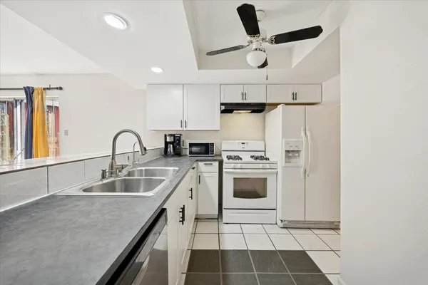 a kitchen with stainless steel appliances granite countertop a sink a stove and a refrigerator